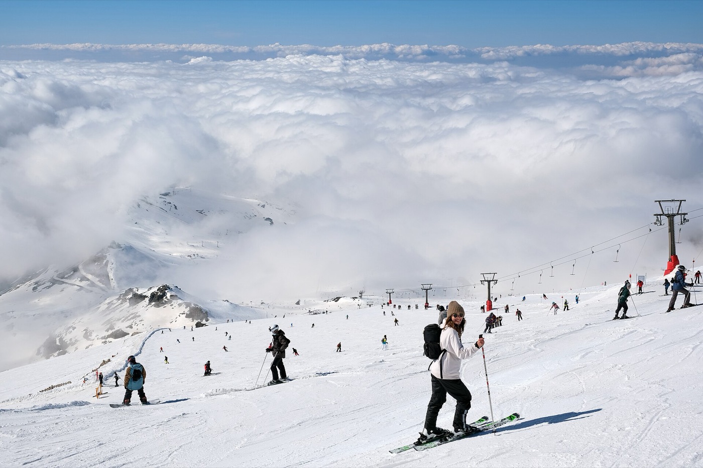 Esquiadores en la parte alta de Sierra Nevada, con un mar de nubes debajo.