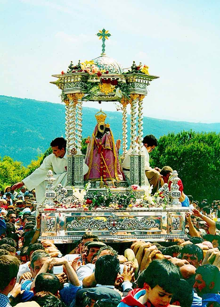 La Virgen de la Cabeza en sus andas, rodeada de romeros, durante la procesión del domingo de romería junto al Santuario.